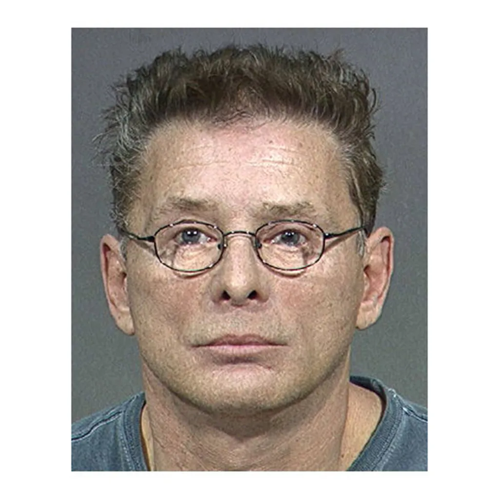 A mugshot of Jeffrey Skilling wearing glasses.