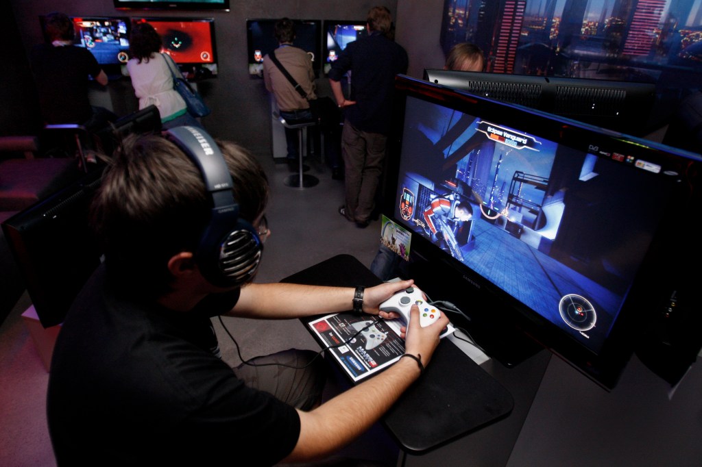 COLOGNE, GERMANY - AUGUST 19: A visitor plays 'Mass Effect 2' at Electronic Arts stand during 'Gamescom' in Germany in August 2009. 