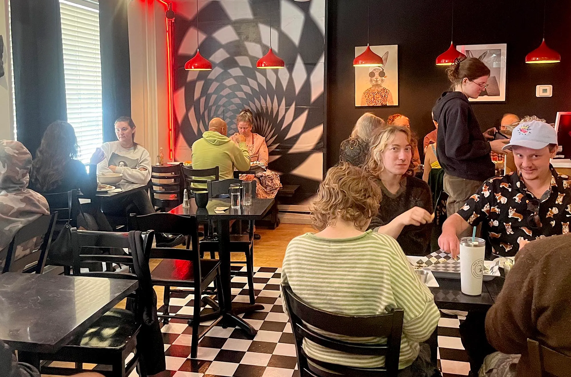 people eating vegan food in a checkered cafe