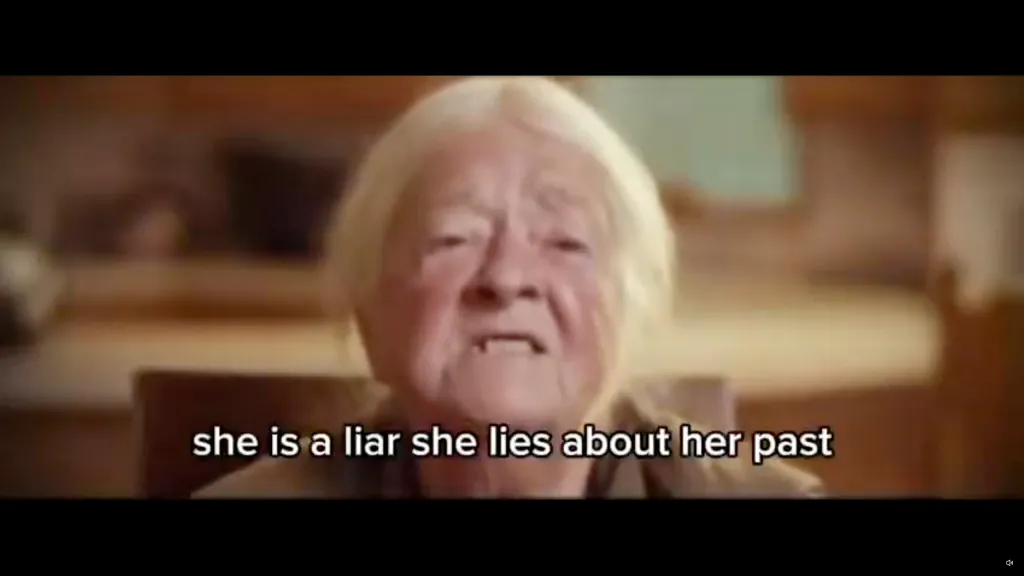 An elderly woman speaking with subtitles that read, 