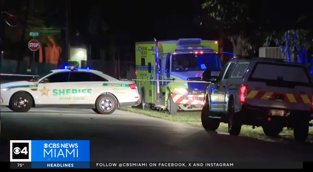 Miami-Dade police and emergency vehicles at a scene at night.