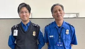 Two TSA officers in blue uniforms.