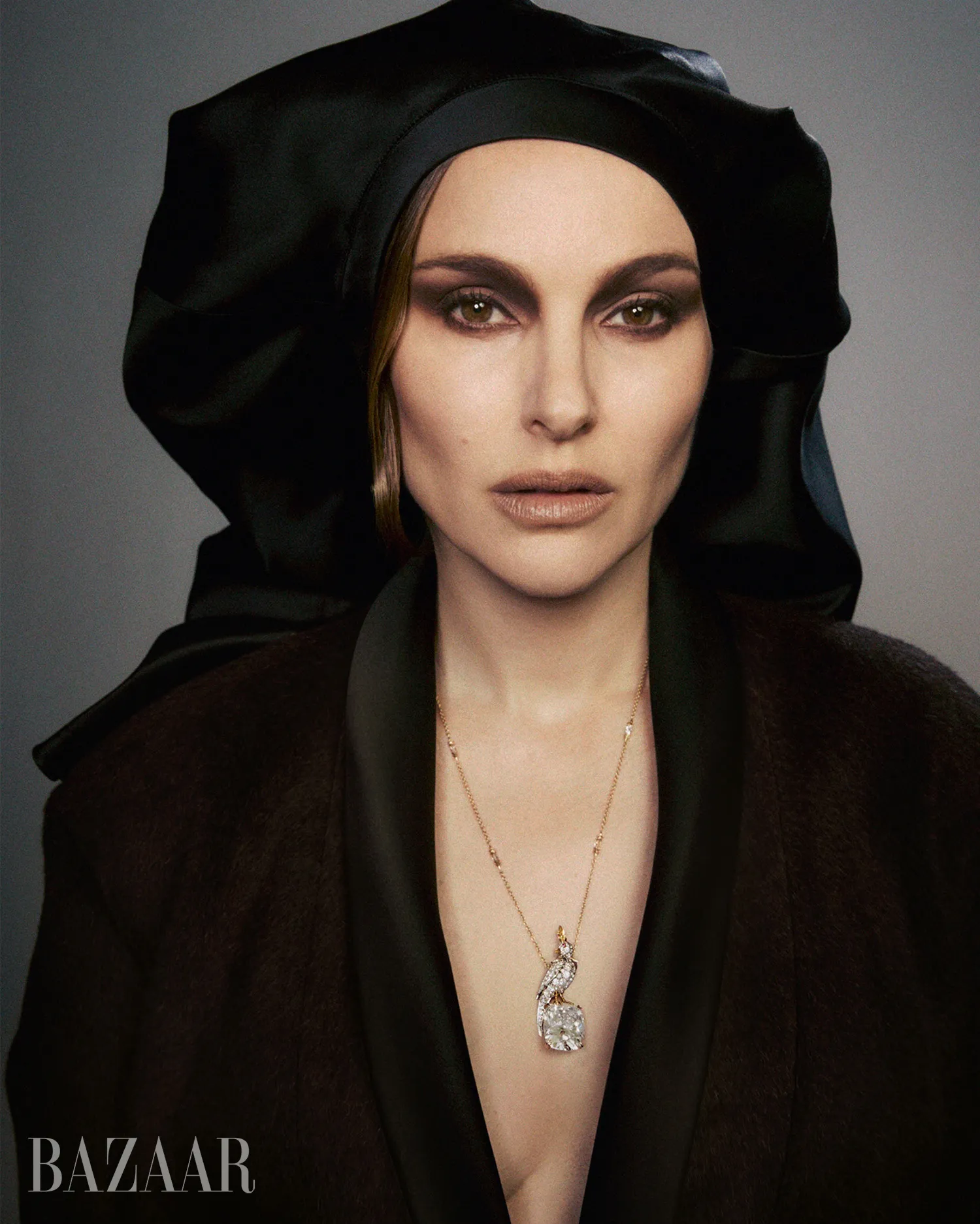Natalie Portman wearing a black head covering and a pendant necklace.