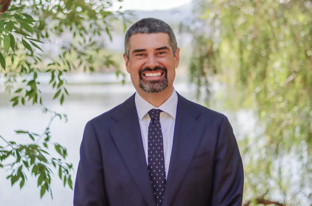 Aaron Baker, Valley Water's chief executive officer, smiling in a suit and tie outdoors.