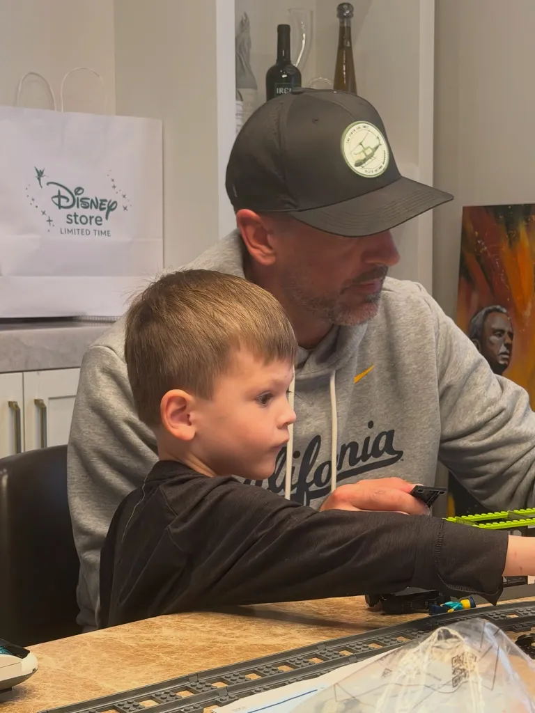Jordan Rodgers building Legos with a child at a table.
