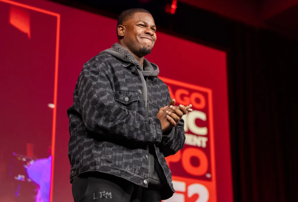 Actor John Boyega smiles and rubs his hands together on stage at C2E2.