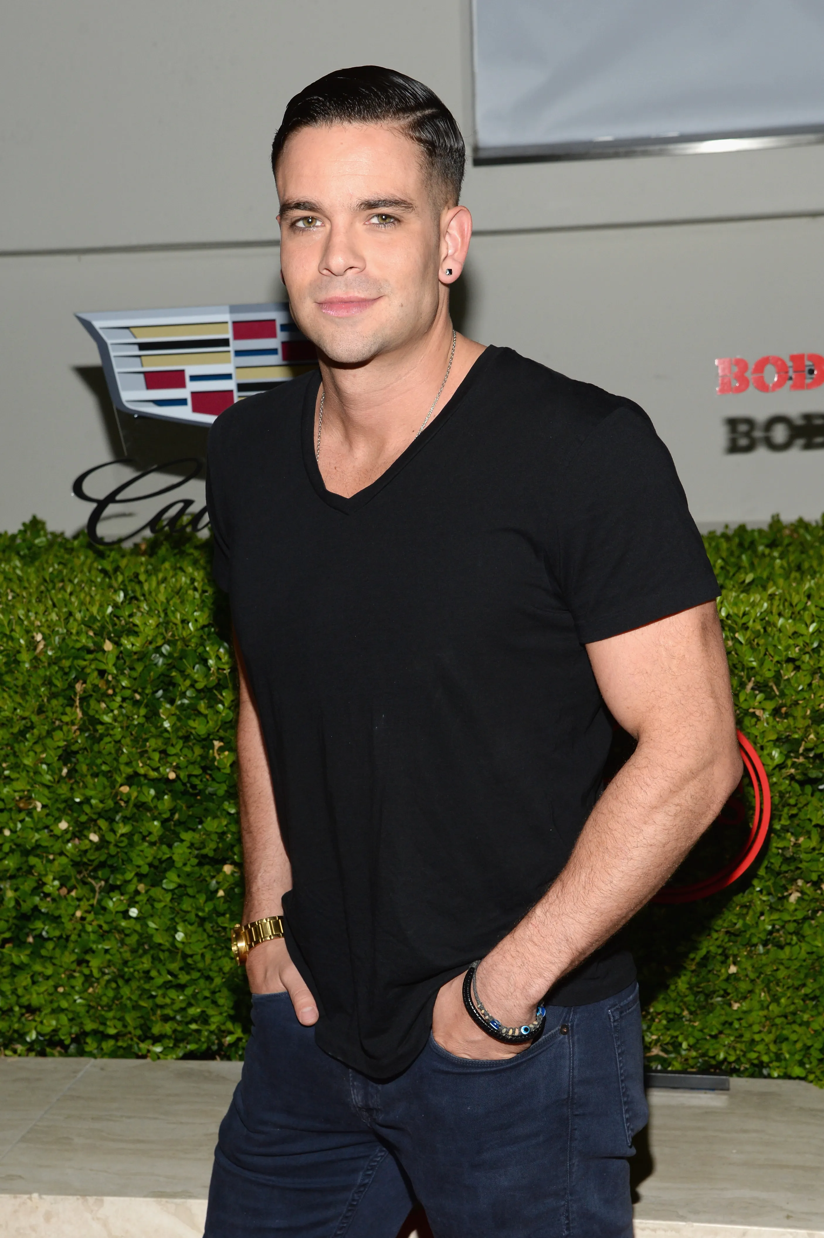 Actor Mark Salling wearing a black v-neck t-shirt and blue jeans.