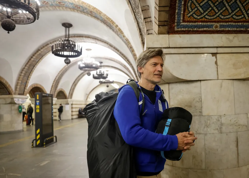 Actor Nikolaj Coster-Waldau takes shelter inside a metro station in Kyiv, holding a sleeping bag and carrying a large backpack.