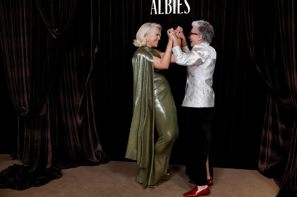 Actors Hannah Waddingham and Emma Thompson hold hands and smile at The Albie Awards.