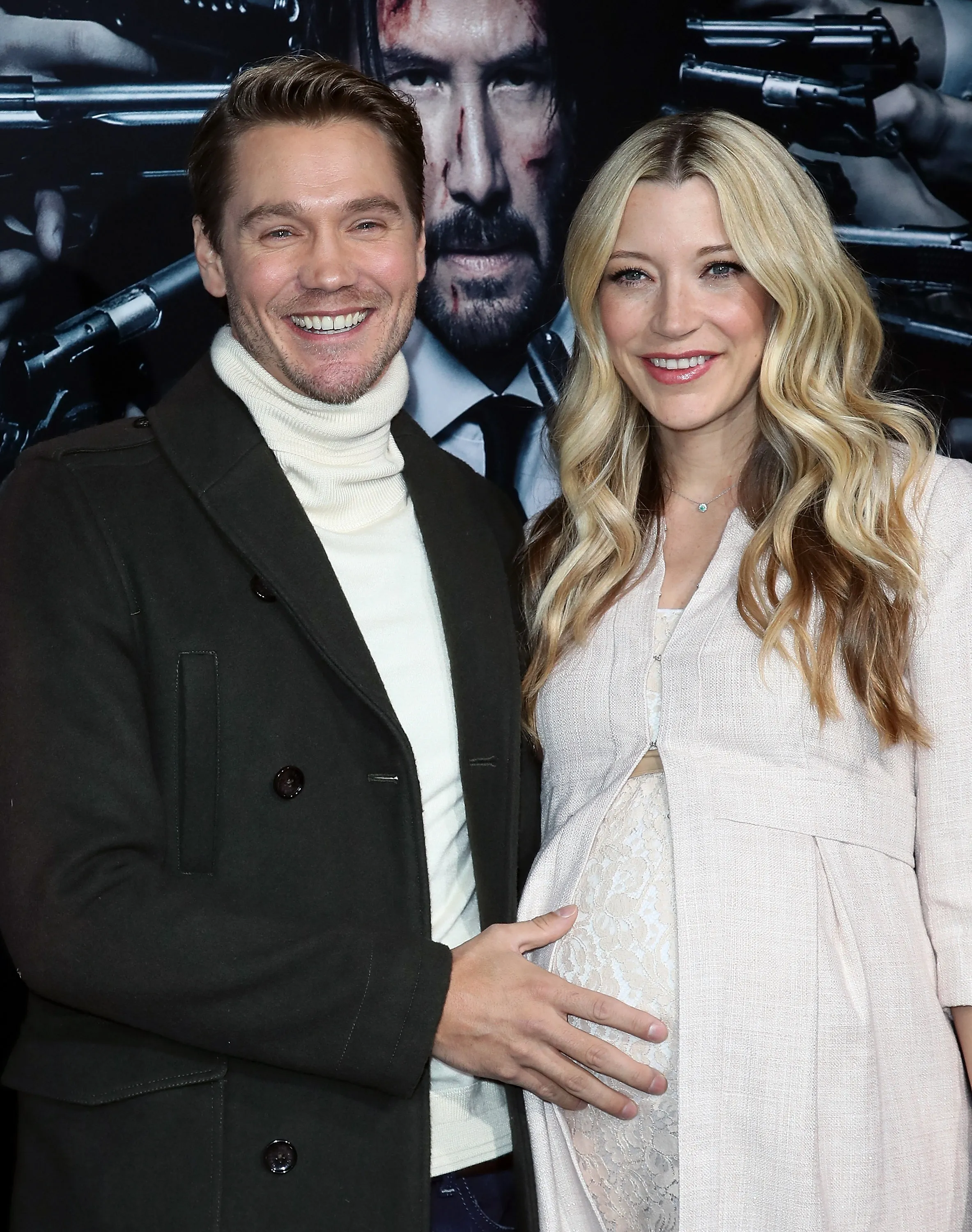 Actors Chad Michael Murray and Sarah Roemer smiling together on a red carpet, with Murray's hand on Roemer's pregnant belly.