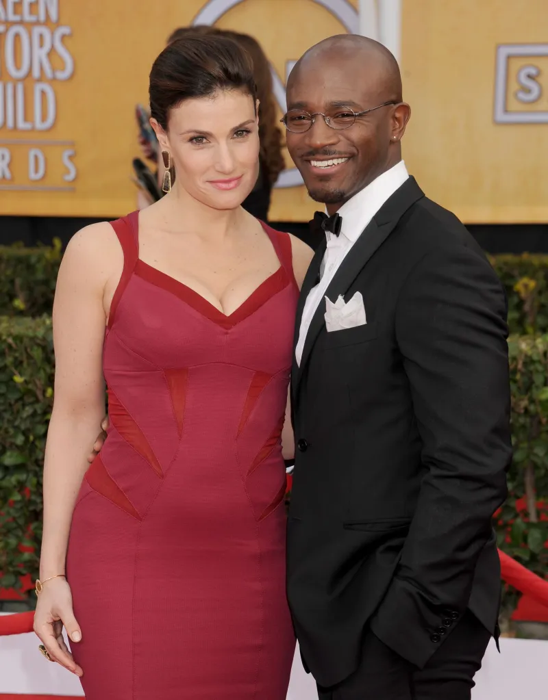 Actors Idina Menzel and Taye Diggs pose on the red carpet at an awards ceremony.
