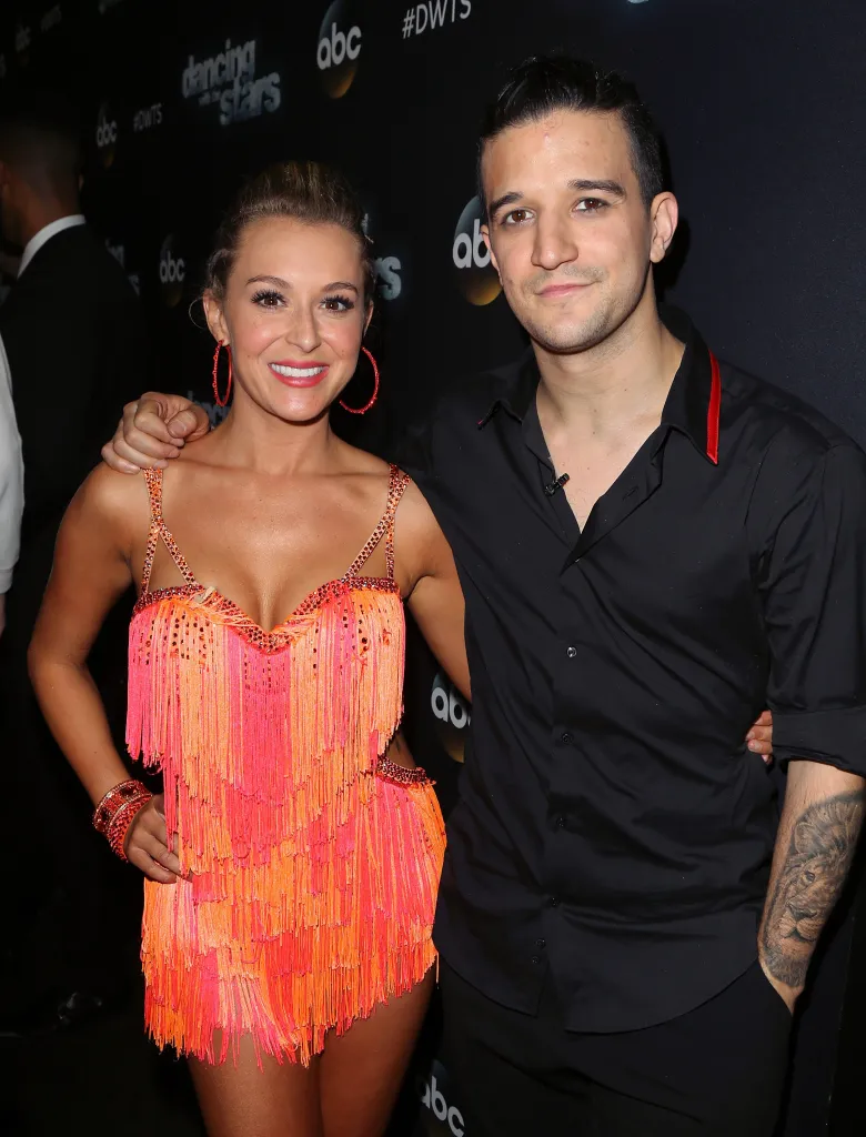 Actress Alexa PenaVega and dancer Mark Ballas posing together at an event.