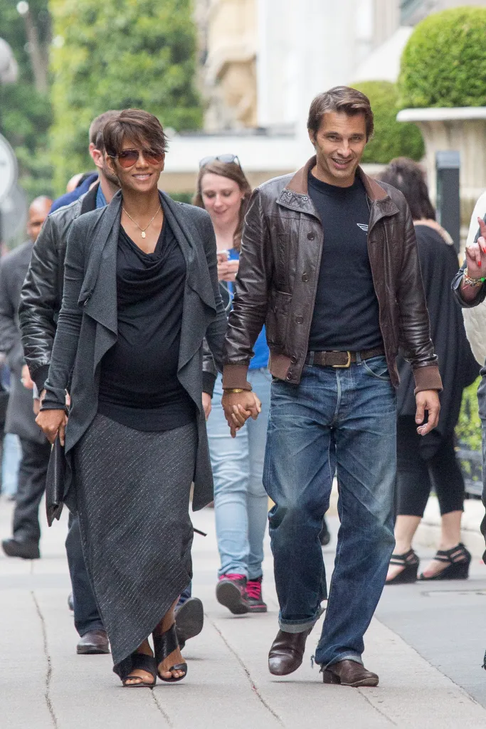 Actress Halle Berry and actor Olivier Martinez walking and holding hands on a street in Paris.