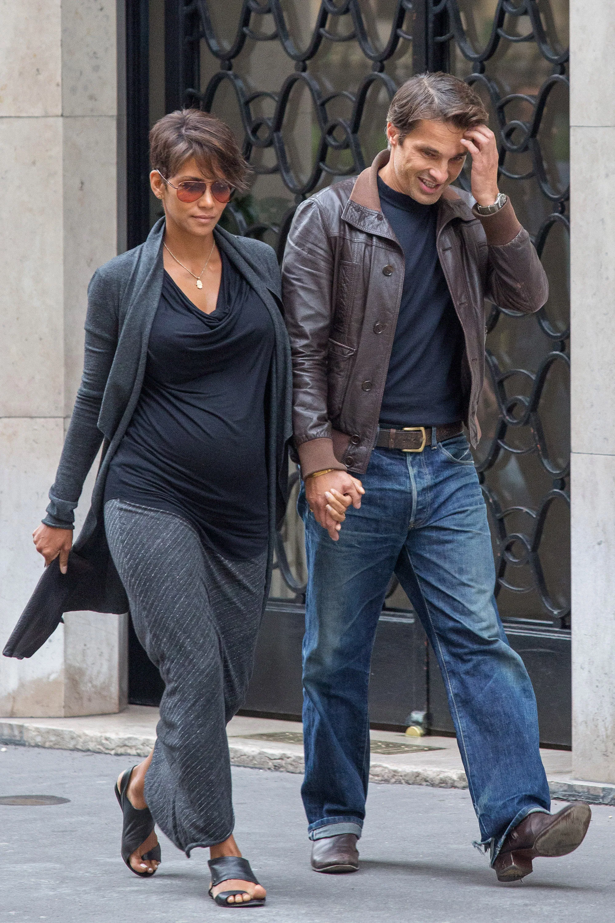 Actress Halle Berry and actor Olivier Martinez holding hands while walking down a street.