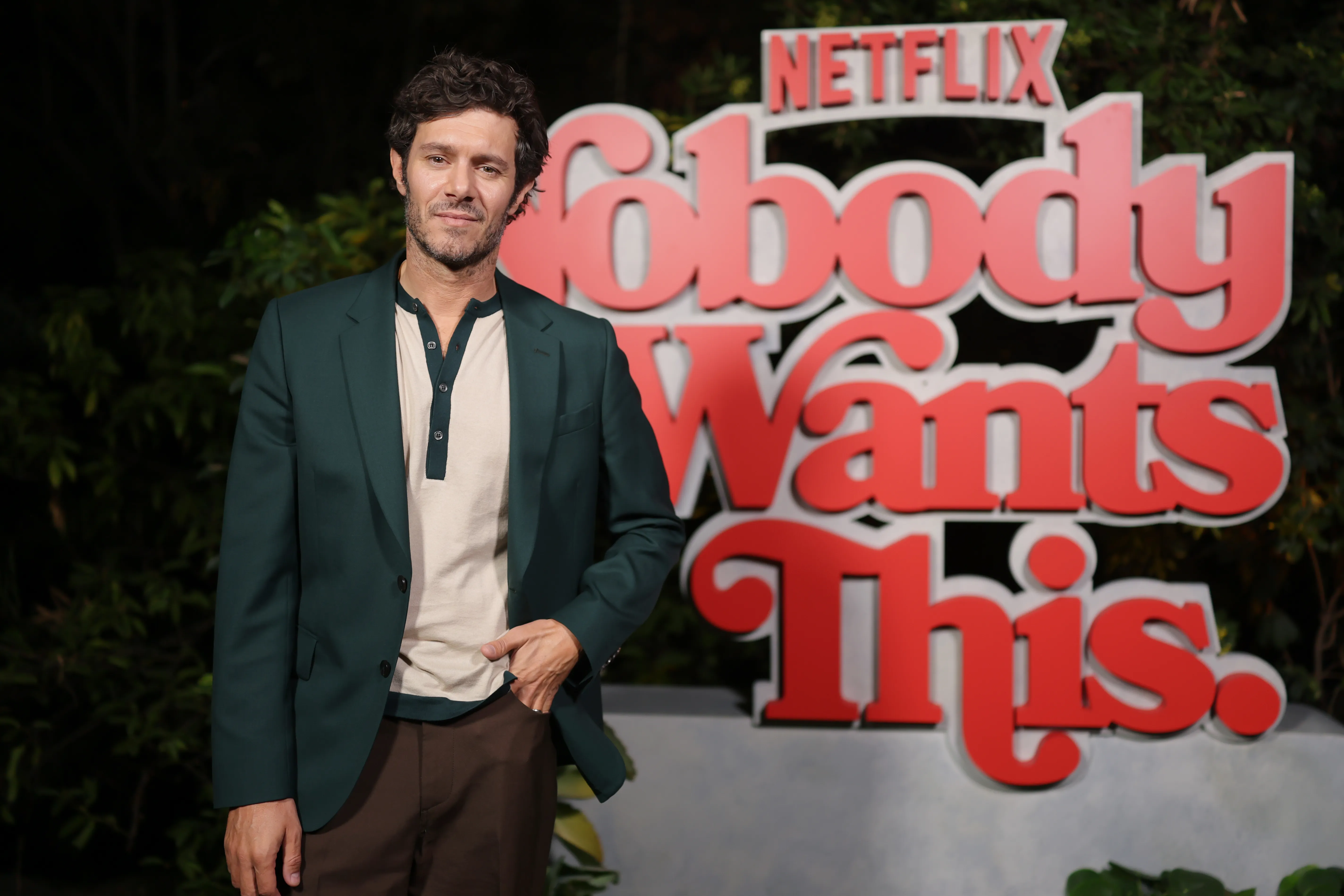 Adam Brody standing in front of a 