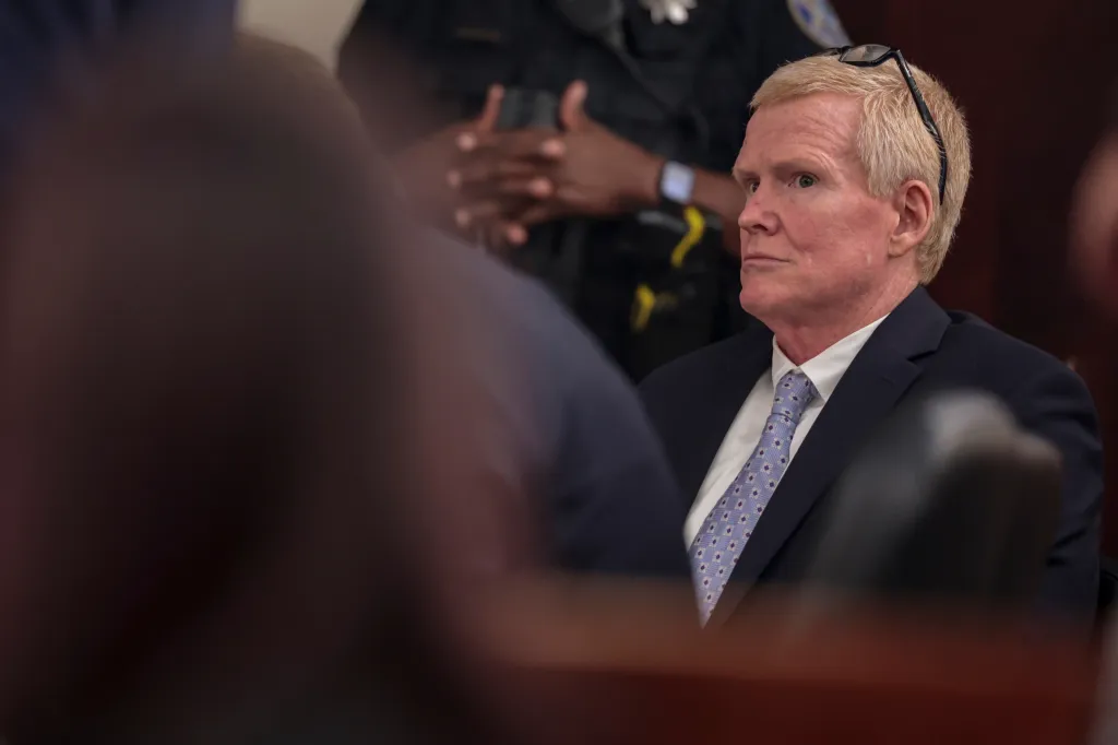 Alex Murdaugh sits in a courtroom wearing a suit and tie during an evidentiary hearing.