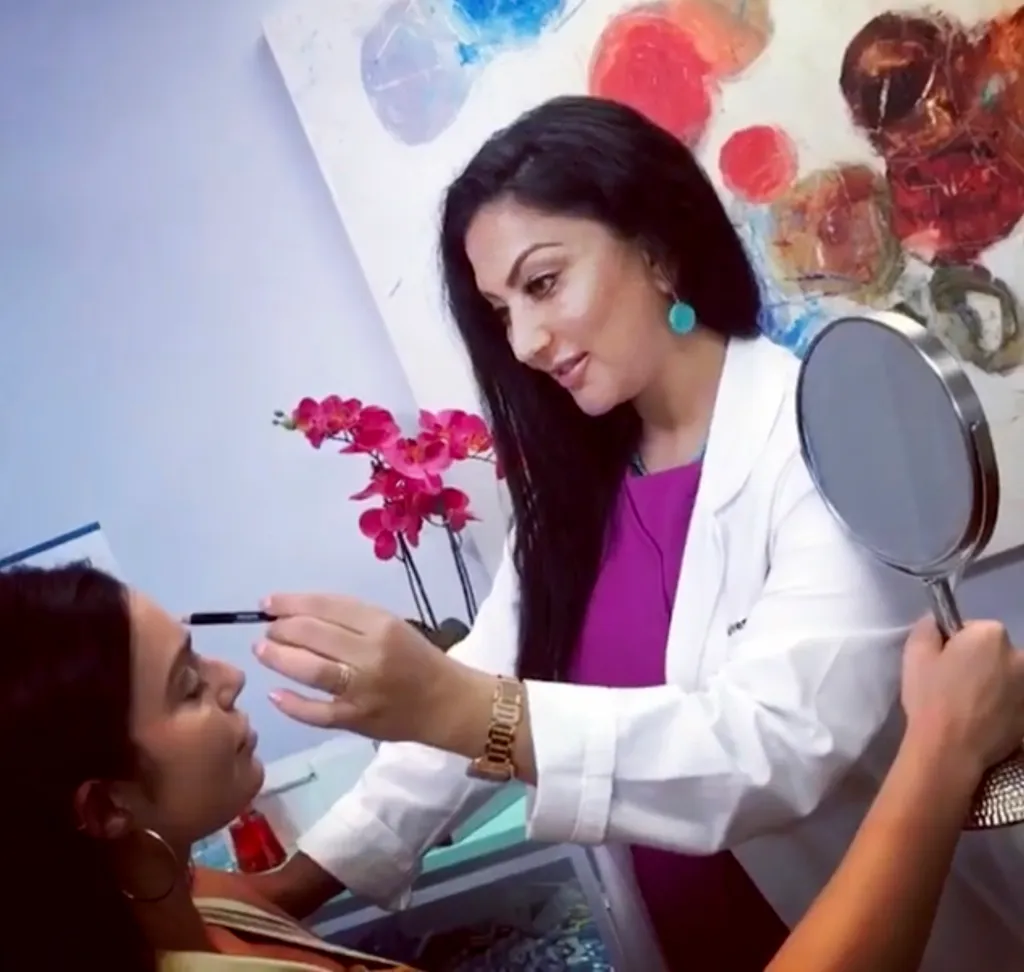 Dr. Violetta Mailyan holding a mirror while examining a patient.