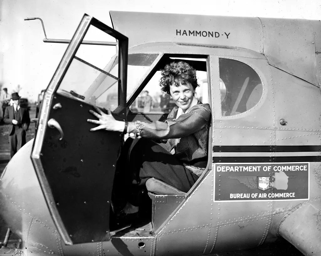 Amelia Earhart looking at the camera from inside a Hammond Y airplane.