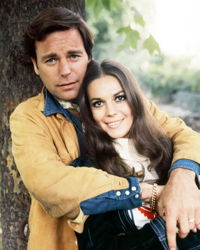 American actors Robert Wagner and his wife Natalie Wood embracing outdoors.