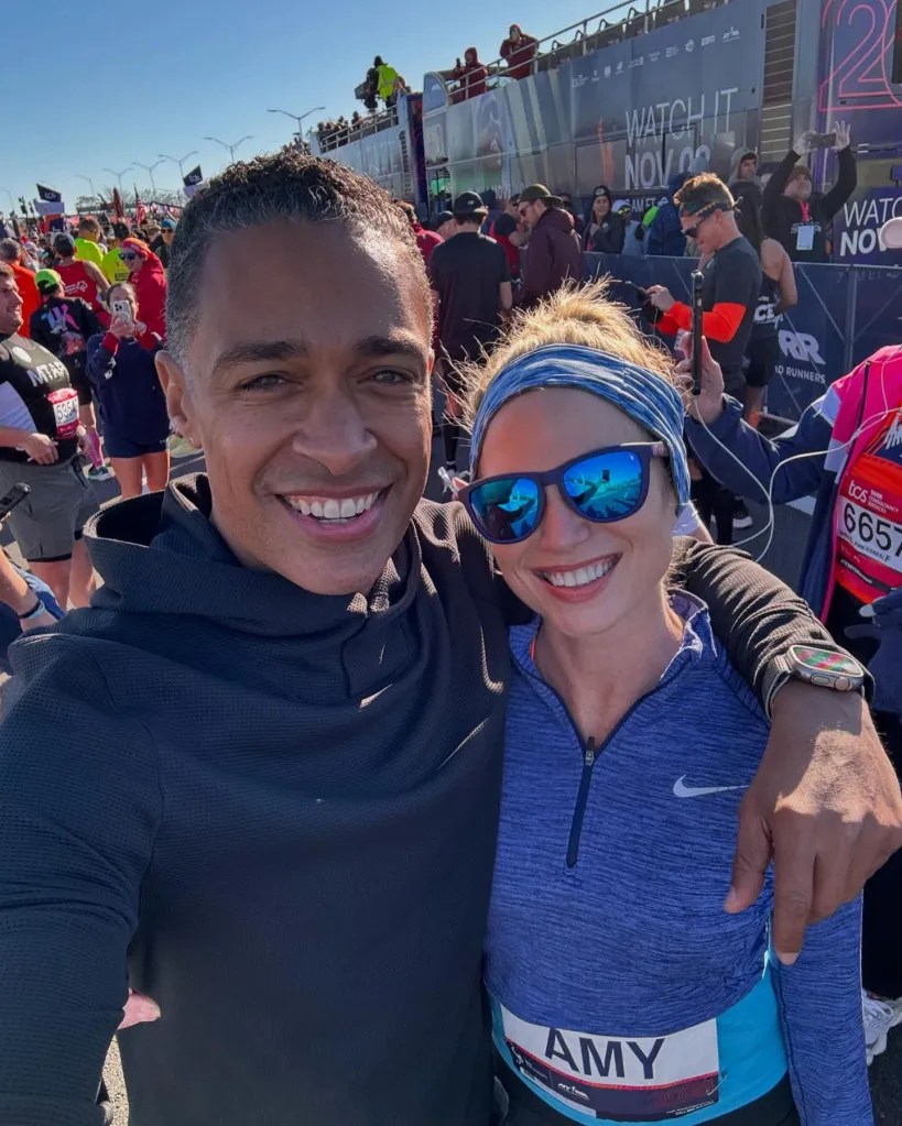 Amy Robach and T.J. Holmes smiling together at a marathon.