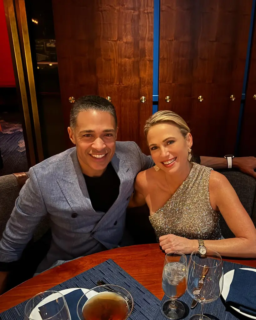 Amy Robach and T.J. Holmes smiling at a restaurant table.