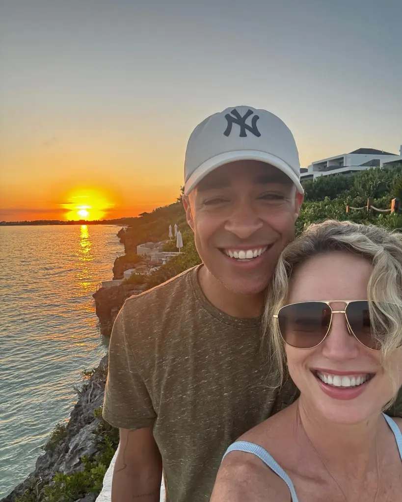 Amy Robach and T.J. Holmes smiling together at sunset by the ocean.