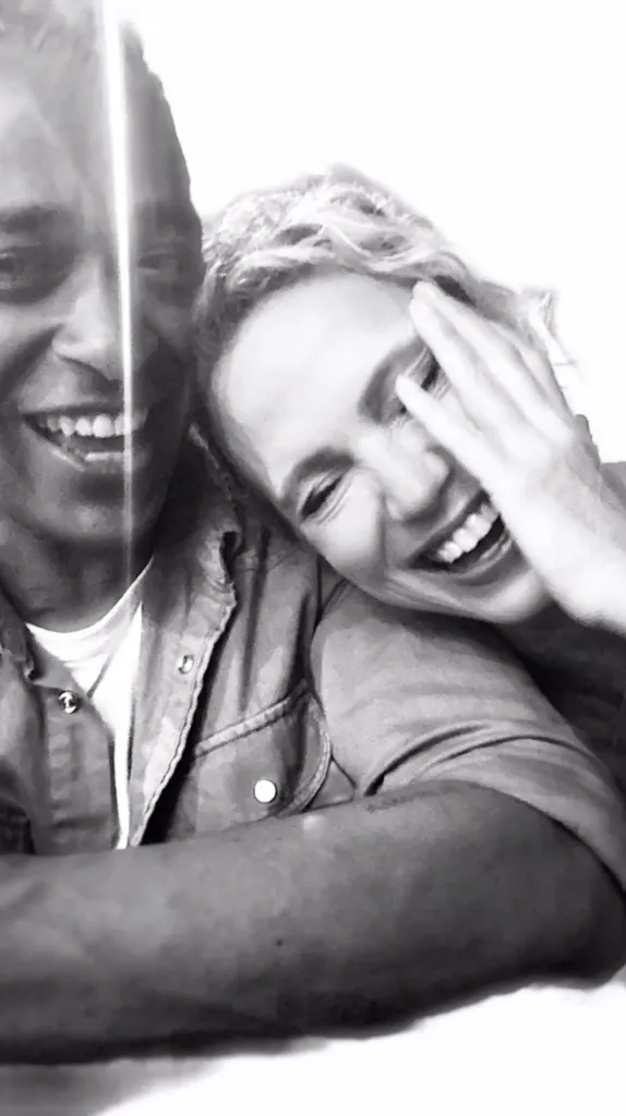 Amy Robach and T.J. Holmes smiling and embracing each other.