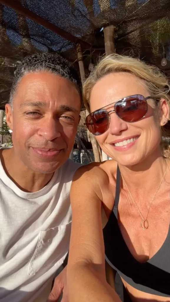 Amy Robach and T.J. Holmes smiling together outdoors.