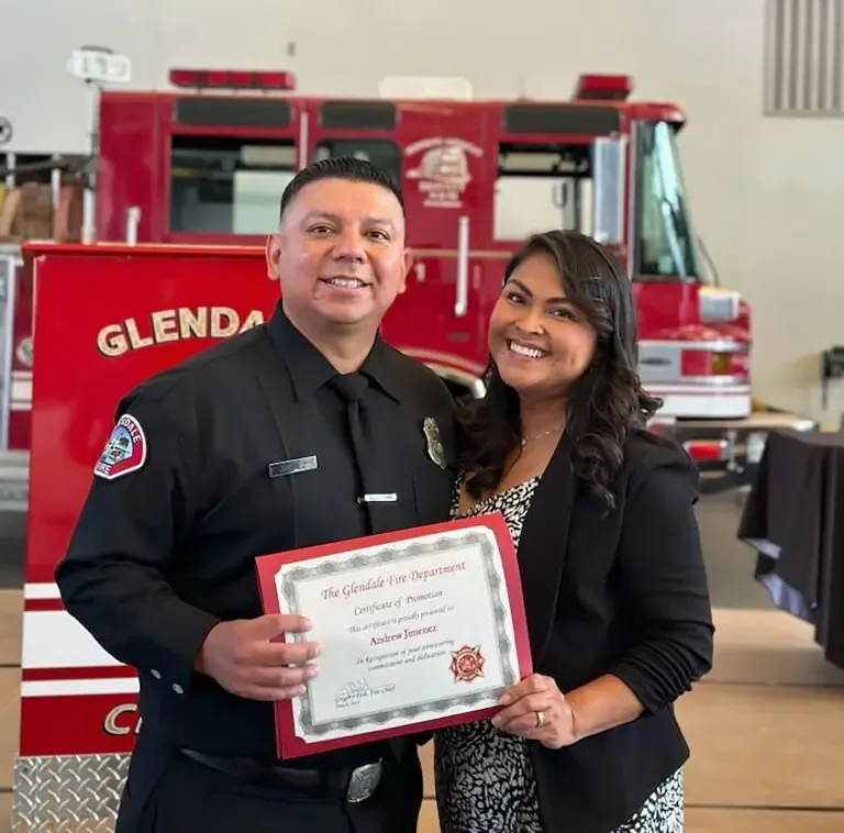 Andrew and Mayra Jimenez holding a Glendale Fire Department certificate in front of a fire engine.