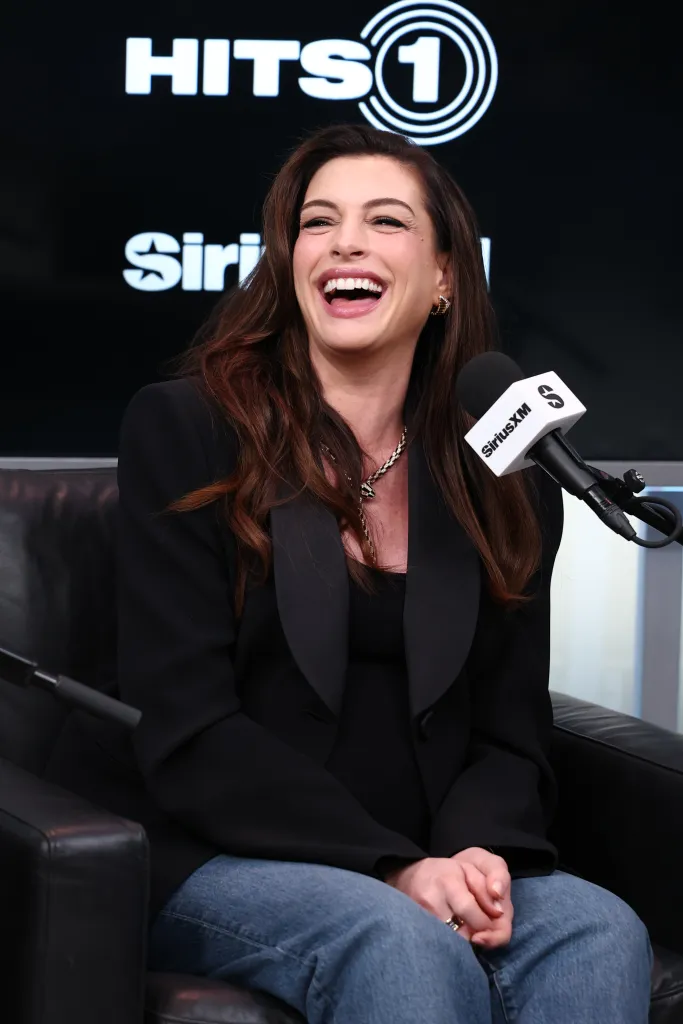 Anne Hathaway laughs while attending SiriusXM's Front Row With The Cast Of