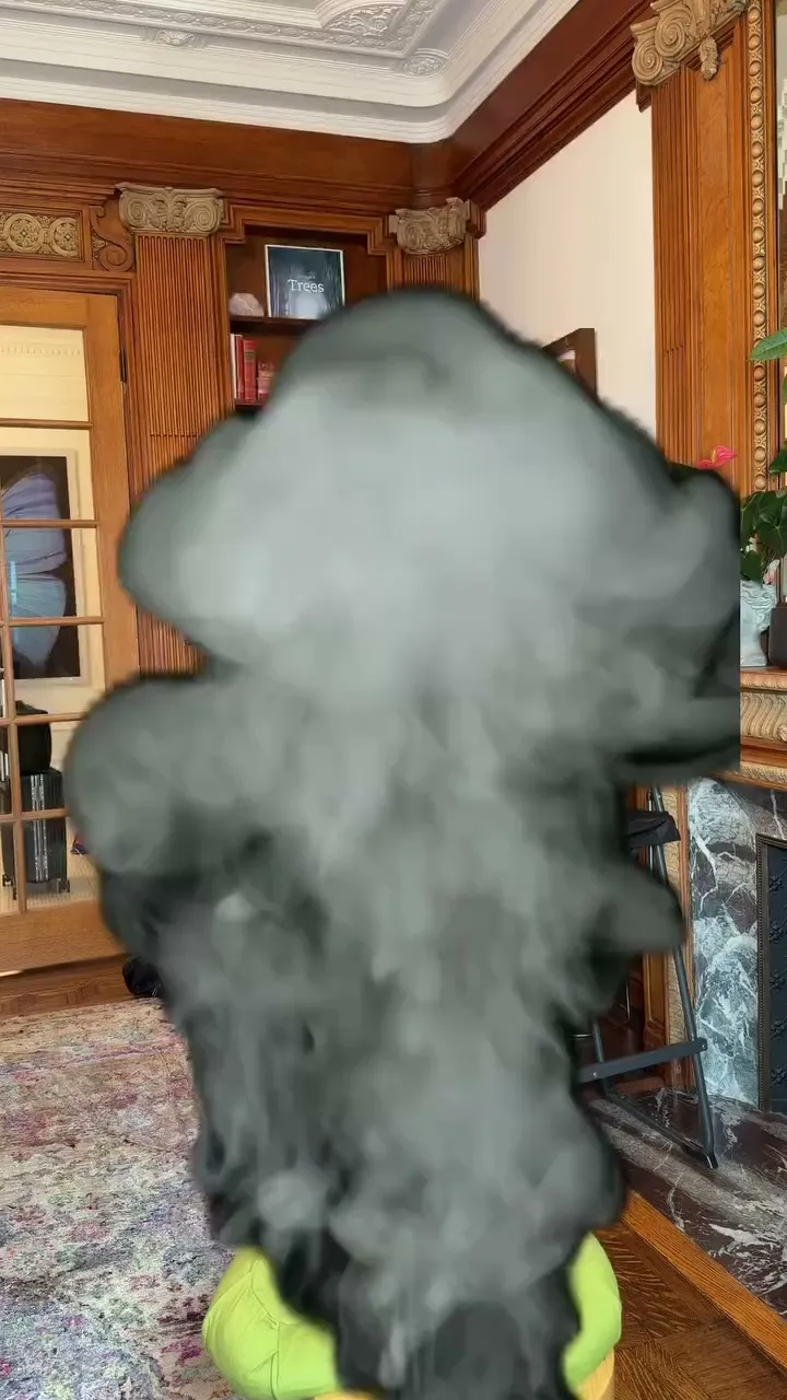 Anne Hathaway vanishes in a puff of smoke in an indoor room.
