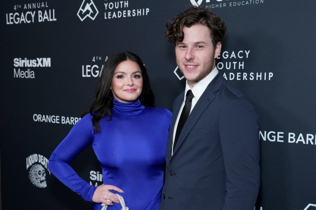 Ariel Winter and Nolan Gould pose together in front of a branded step-and-repeat backdrop at the 4th Annual Legacy Ball.