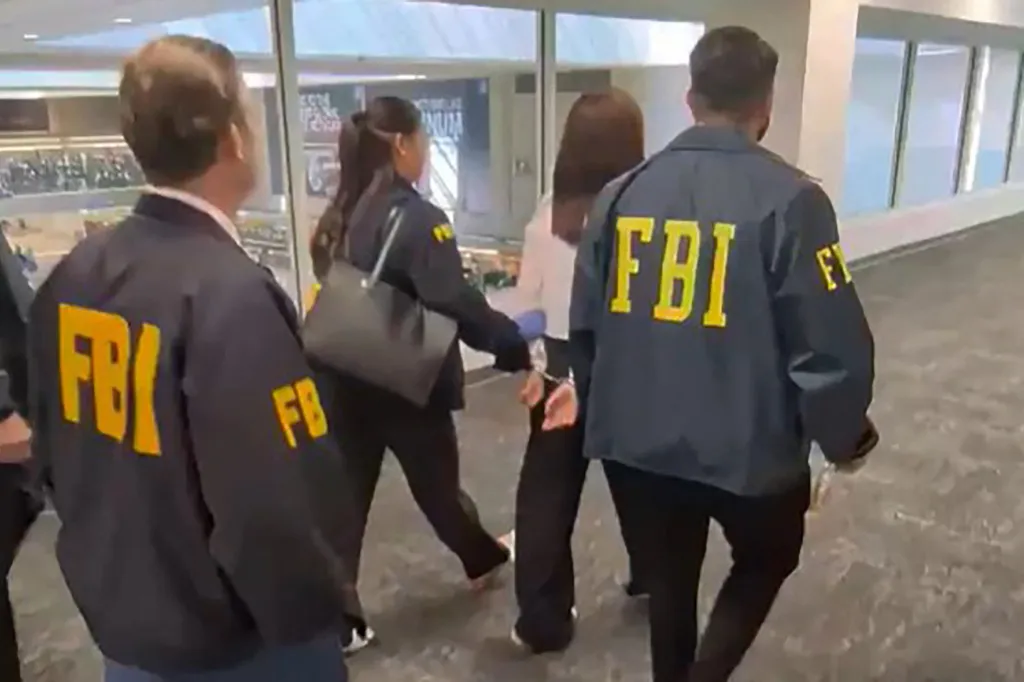 FBI agents escort Wanying Zhang, accused of spying for China, at the Los Angeles airport.