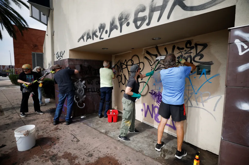 Artists and social activists clean graffiti off a building's exterior in downtown Los Angeles.