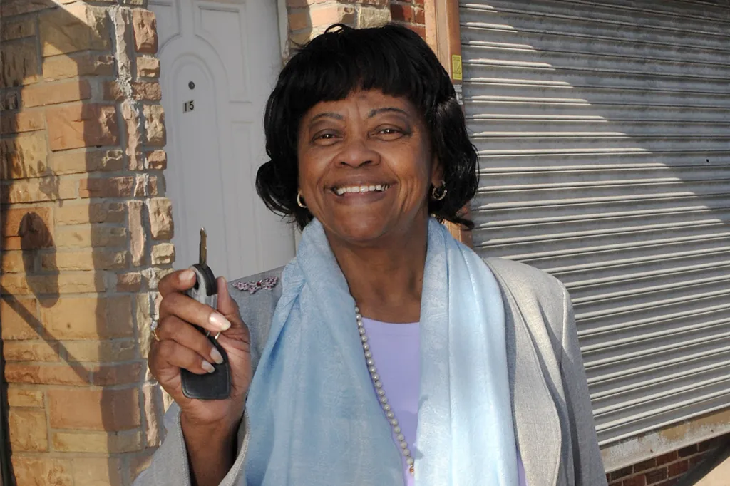 Assemblywoman Vivian E. Cook standing outside her Queens office holding a set of keys.