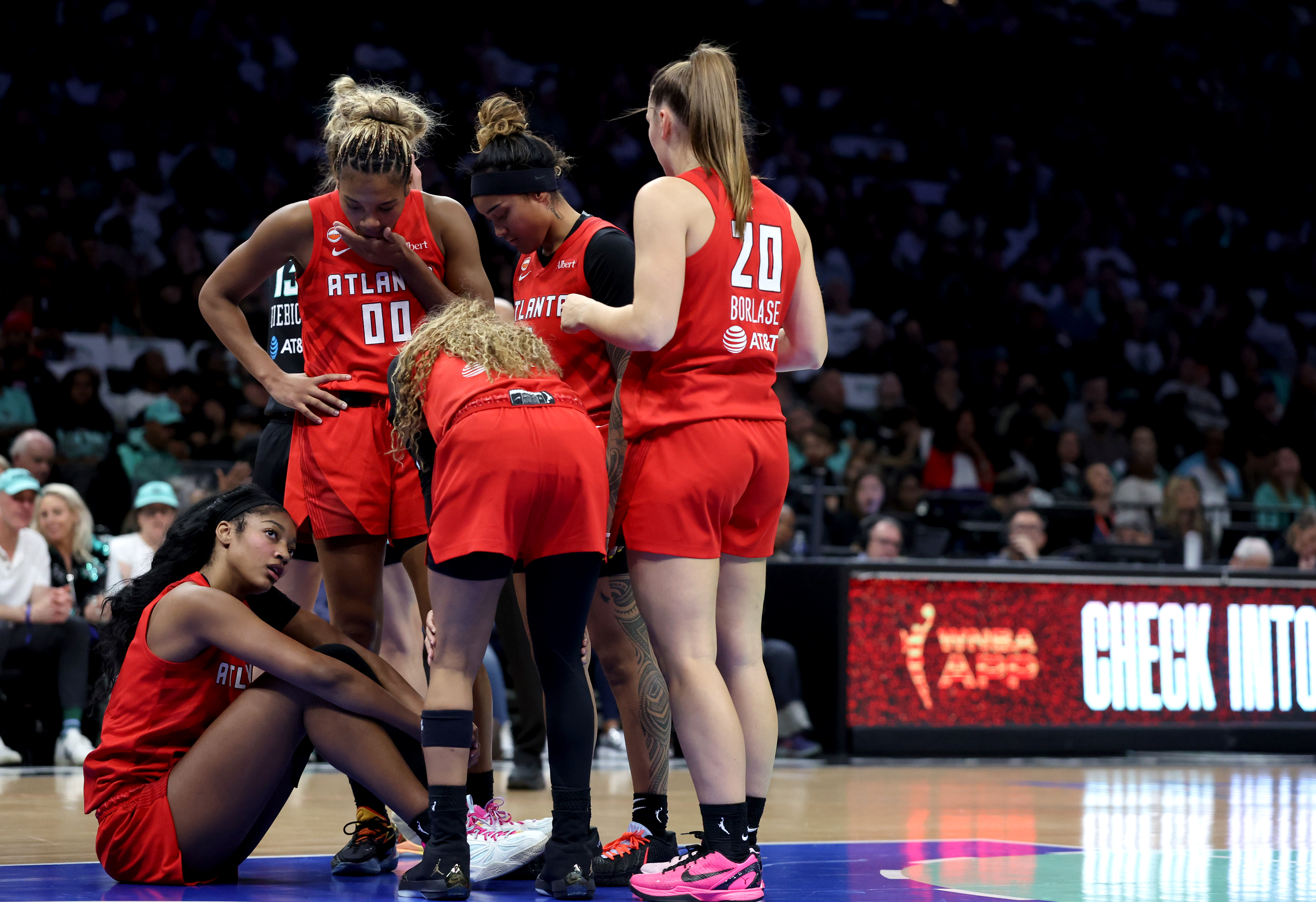 Atlanta Dream players check on Angel Reese after she was fouled during a WNBA playoff game.