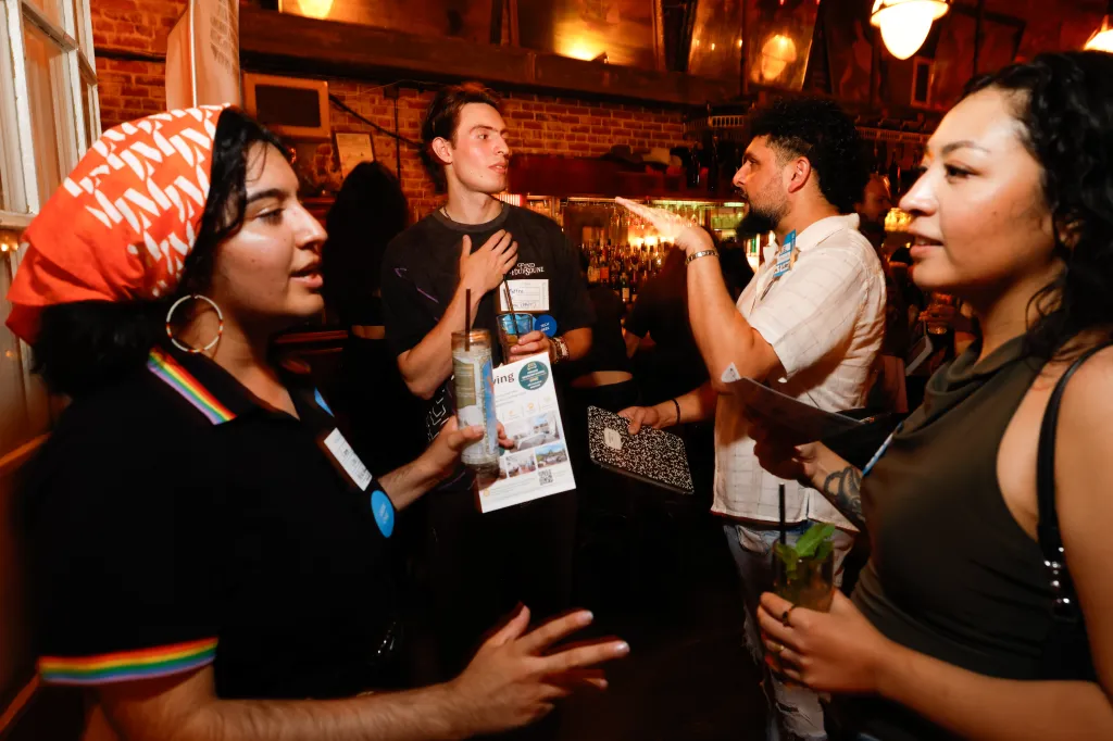 People mingling and talking at the Speed Roommating event at Sassafras Saloon in Los Angeles.