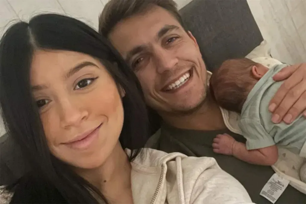 Spencer and McKensi Skelton smiling while holding a baby.