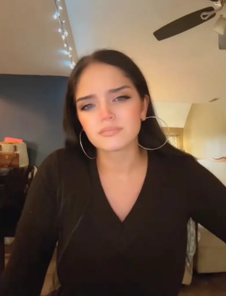Autumn Urker wearing a black V-neck top and large hoop earrings.