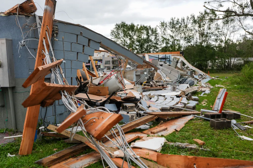 The collapsed back wall of the Milton Quick Stop, exposing the interior and leaving piles of rubble and exposed wiring on the ground.
