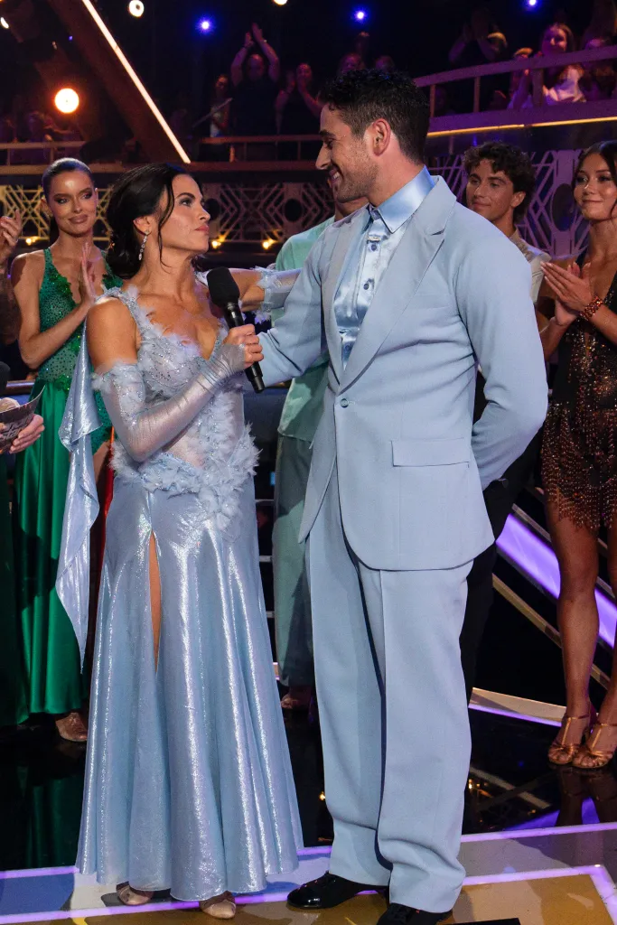 Jenna Dewan holding a microphone and talking to Alan Bersten on Dancing with the Stars.