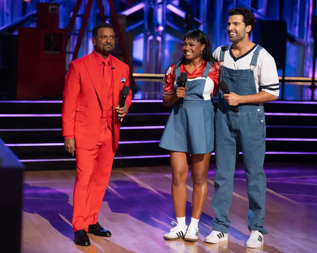 Alfonso Ribeiro, Tatyana Ali, and Jan Ravnik holding microphones on a stage.
