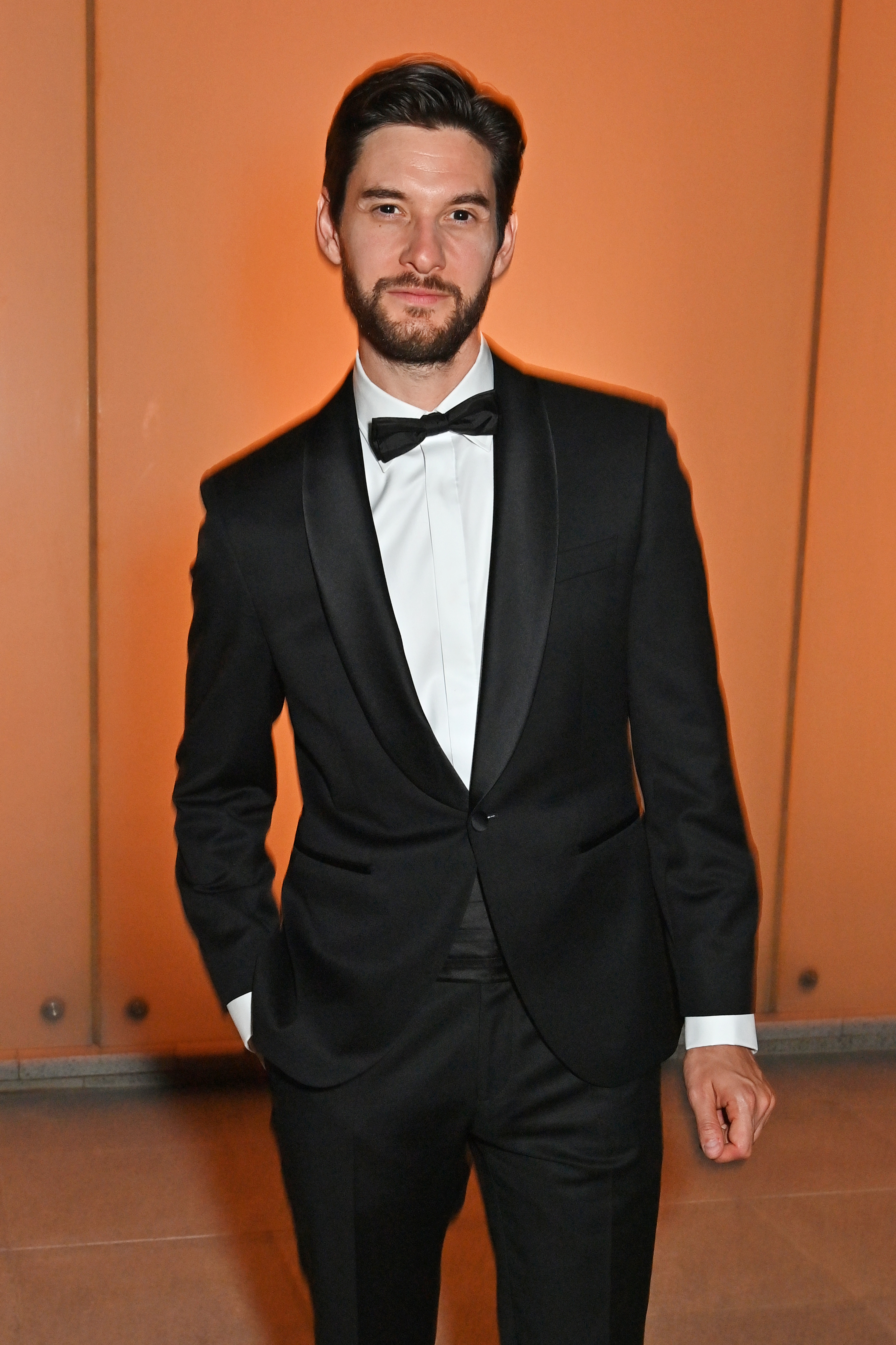 Ben Barnes in a black tuxedo with a bow tie.