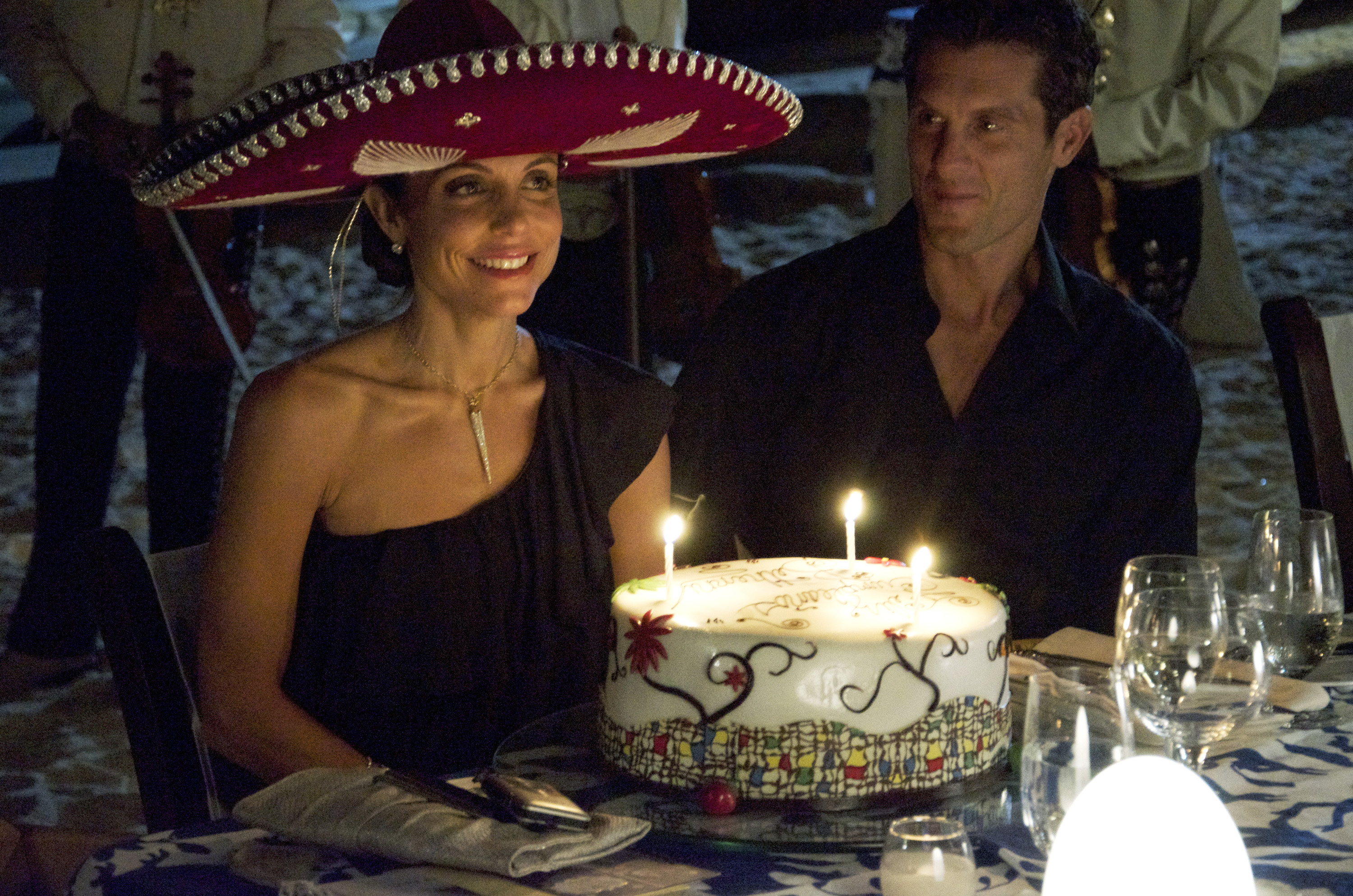 Bethenny Frankel wearing a sombrero and Jason Hoppy sitting at a table with a birthday cake.