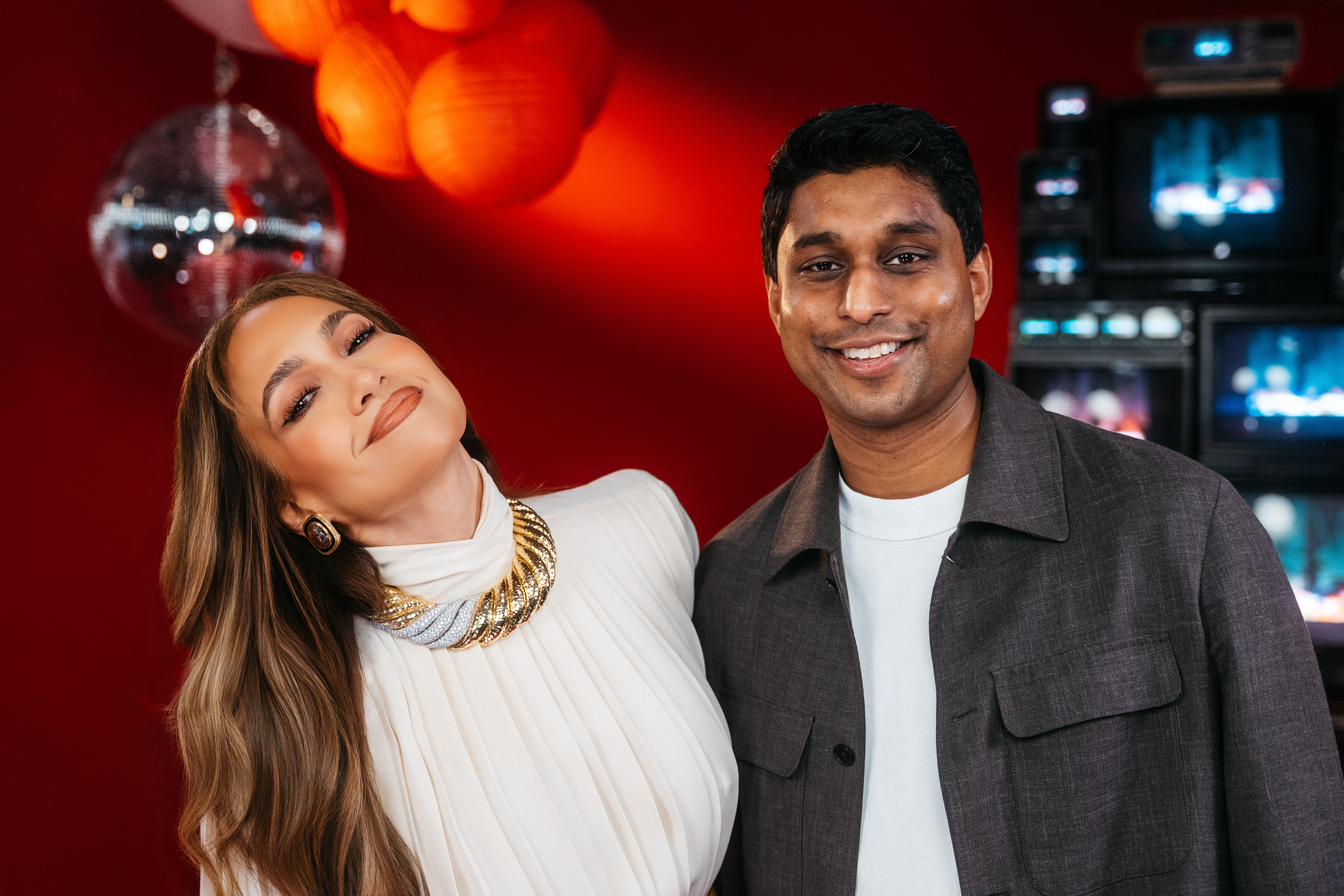 Bilt Founder and CEO Ankur Jain and Jennifer Lopez pose together in front of a red backdrop.