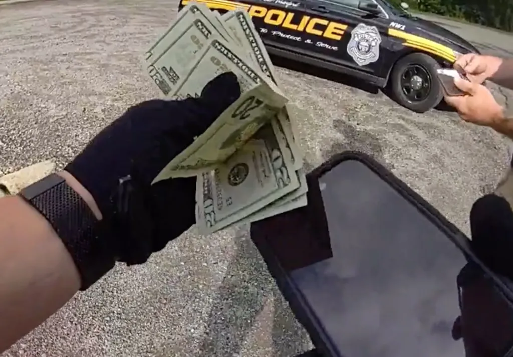 Body camera footage shows Jed York holding a wad of cash during his arrest in East Palestine, Ohio.