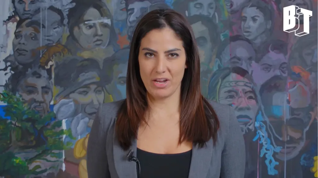 Rania Khalek in front of a mural.