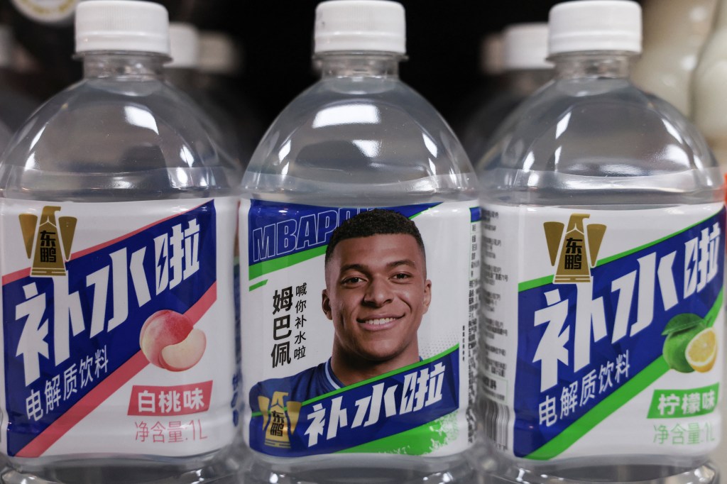 Bottled drinks by Eastroc Beverage featuring French soccer player Kylian Mbappe are displayed on a store shelf in Beijing.