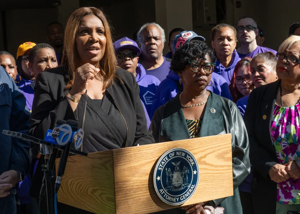 New York Attorney General Letitia James speaks at a press conference regarding home theft, flanked by Bronx District Attorney Darcel Clark and supporters.