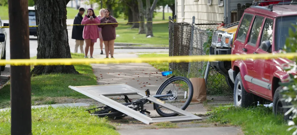 Bystanders gather near the site of a reported shooting where multiple people were killed at a home on Perry St. in Erie, Pa., Oct. 10, 2026.